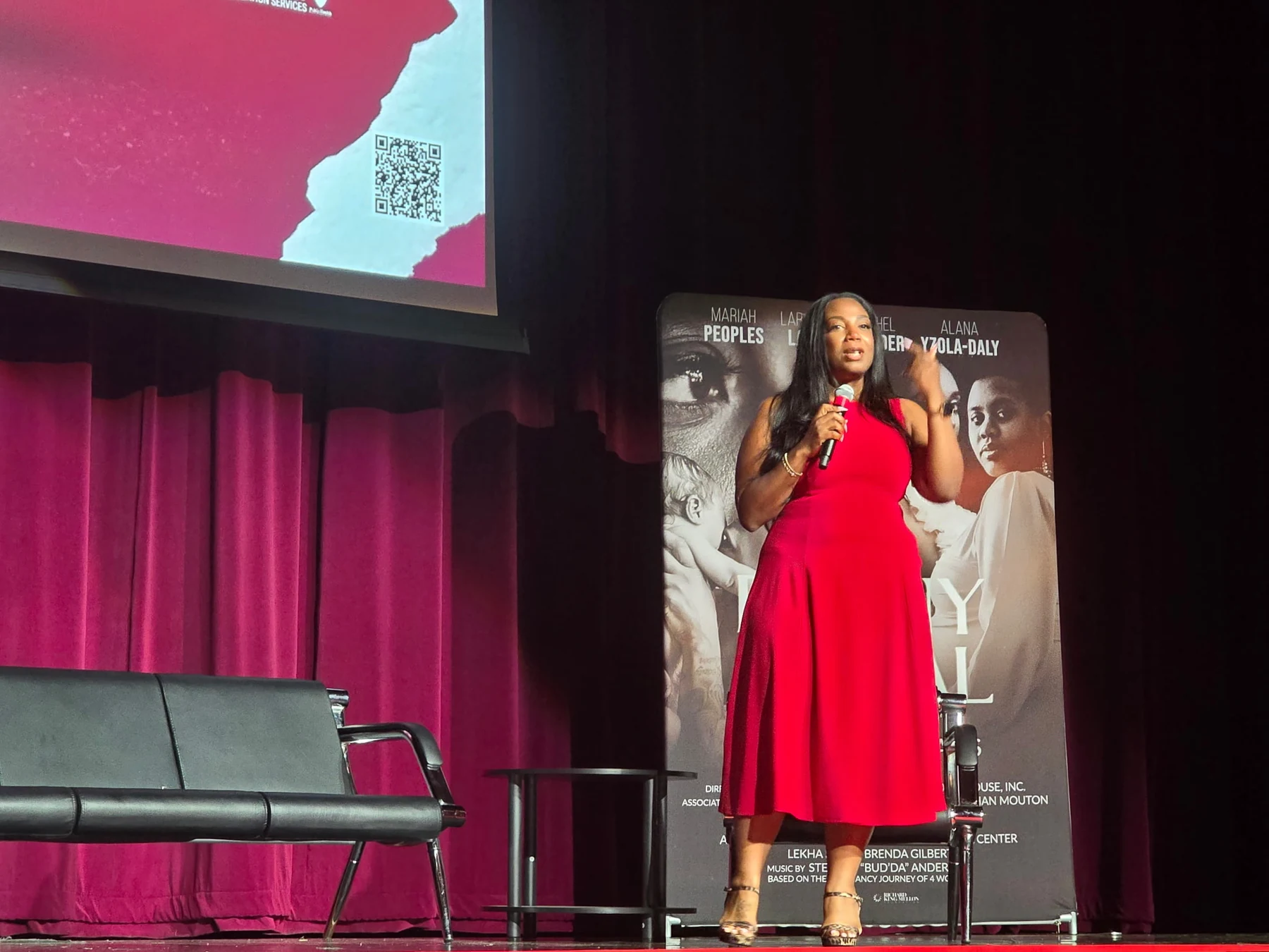 Kyra Betts speaking on a theater stage